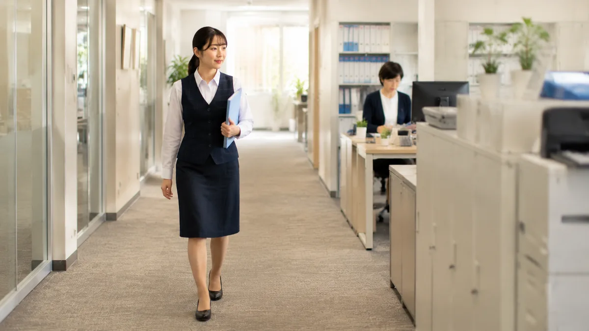 職場で必要な関係だけ保ちながら、適度な距離感を意識して働く30代女性の様子。 