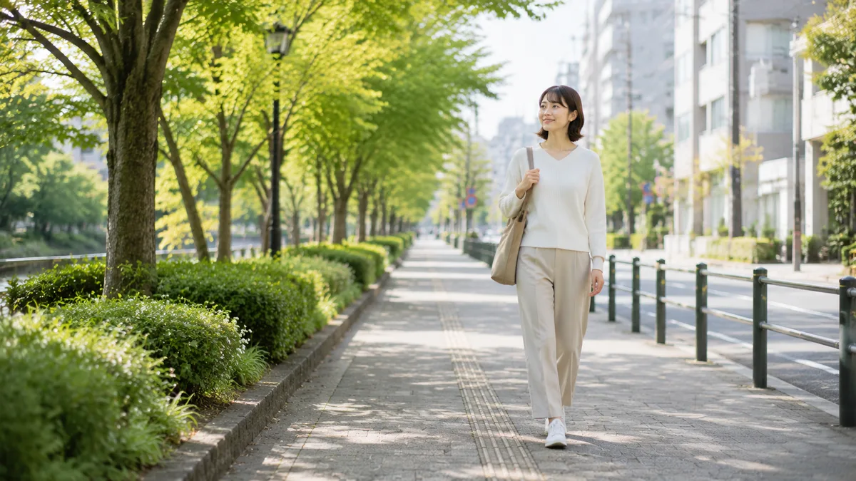 職場環境や働き方を整理し、これからの方向性を考えながら街中の道を歩く女性会社員の画像。自然の中で前を向いて進む様子を表現している。